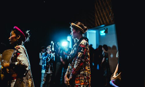 Photographers taking pictures of two women at an event.