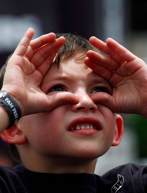 custom content - A boy looking up and shielding his eyes from the sun.