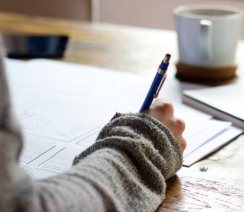 A person writing at a desk.