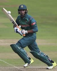 Cricket player swings bat at ball.