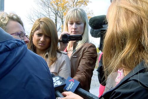 The Canadian Press reporter Allison Jones filing an interview outside with other reporters
