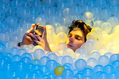 Man taking a selfie in a pool of balls.