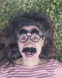 Girl wearing Groucho Marx glasses with fake eyebrows and mustache.