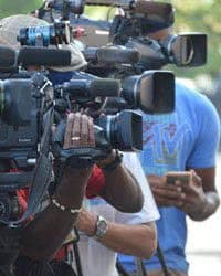 A row of videographers holding video cameras.