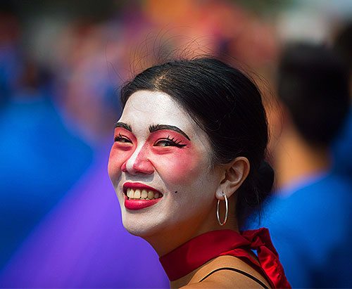 Photo of a smiling woman with theater make-up on.