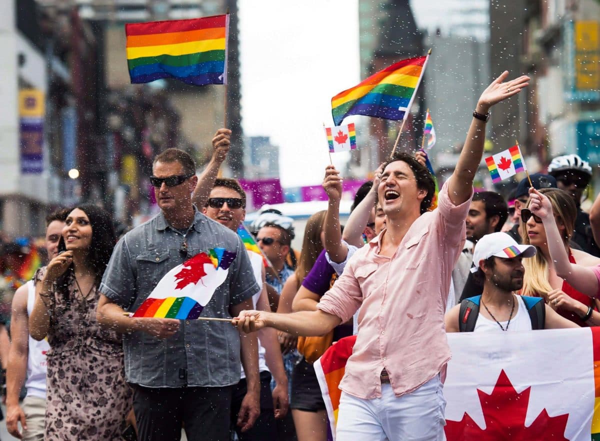 Prime Minister Justin Trudeau gets splashed with water as he waves a flag while taking part in the annual Pride Parade in Toronto.