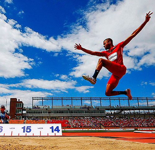 Athlete pictured in midair doing the long jump.