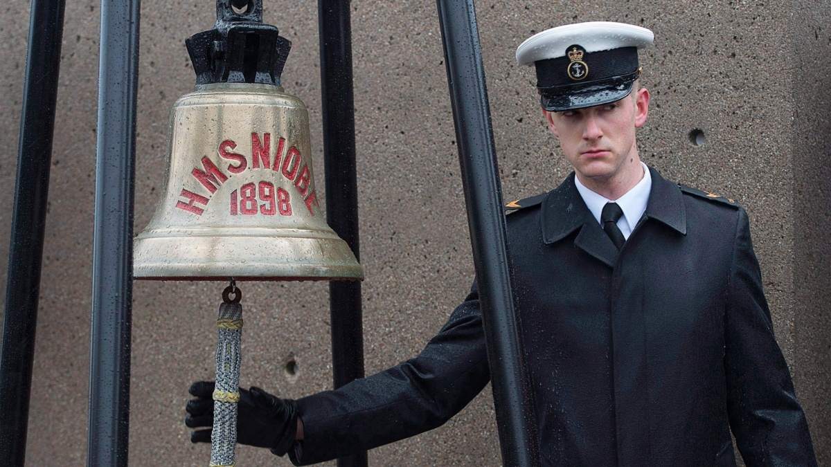 a sailor rings a bell on the anniversary of the Halifax Explosion
