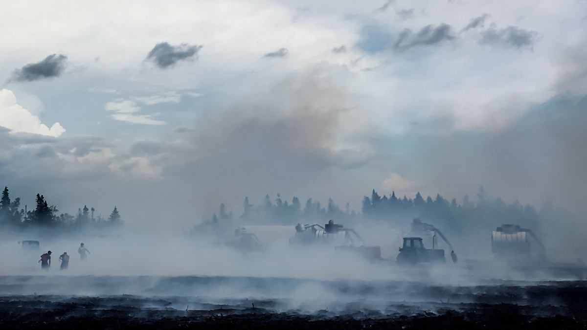 firefighters putting out a peat-bog fire in New Brunswick