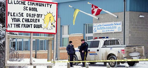 Two police officers stand out front of La Loche Community School