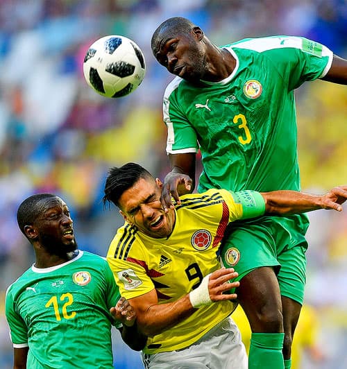 Colombia's Radamel Falcao, center, jumps for the ball with Senegal's Kalidou Koulibaly, right, and Senegal's Youssouf Sabaly, left, during the group H match between Senegal and Colombia