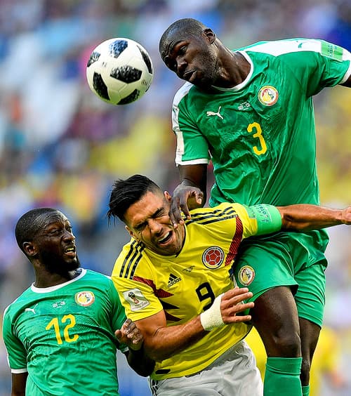 Colombia's Radamel Falcao, center, jumps for the ball with Senegal's Kalidou Koulibaly, right, and Senegal's Youssouf Sabaly, left, during the group H match between Senegal and Colombia