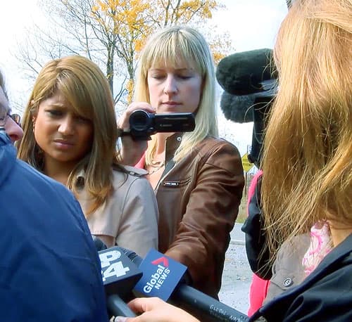 The Canadian Press reporter Allison Jones filing an interview outside with other reporters