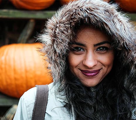 woman smiling by pumpkin