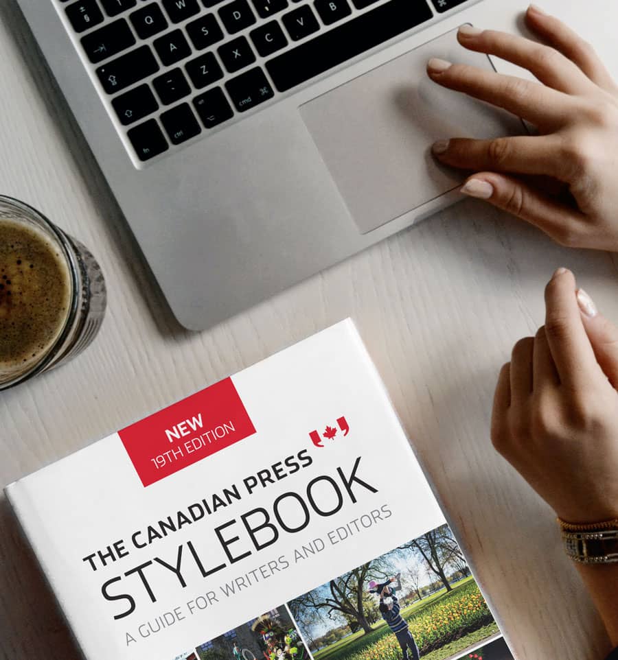 The Stylebook near a laptop where someone is working