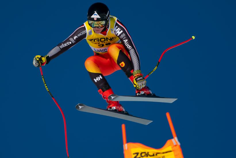 A skiier gets air coming past a gate