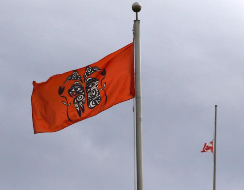 An image of an orange flag with a Canadian flag in the background